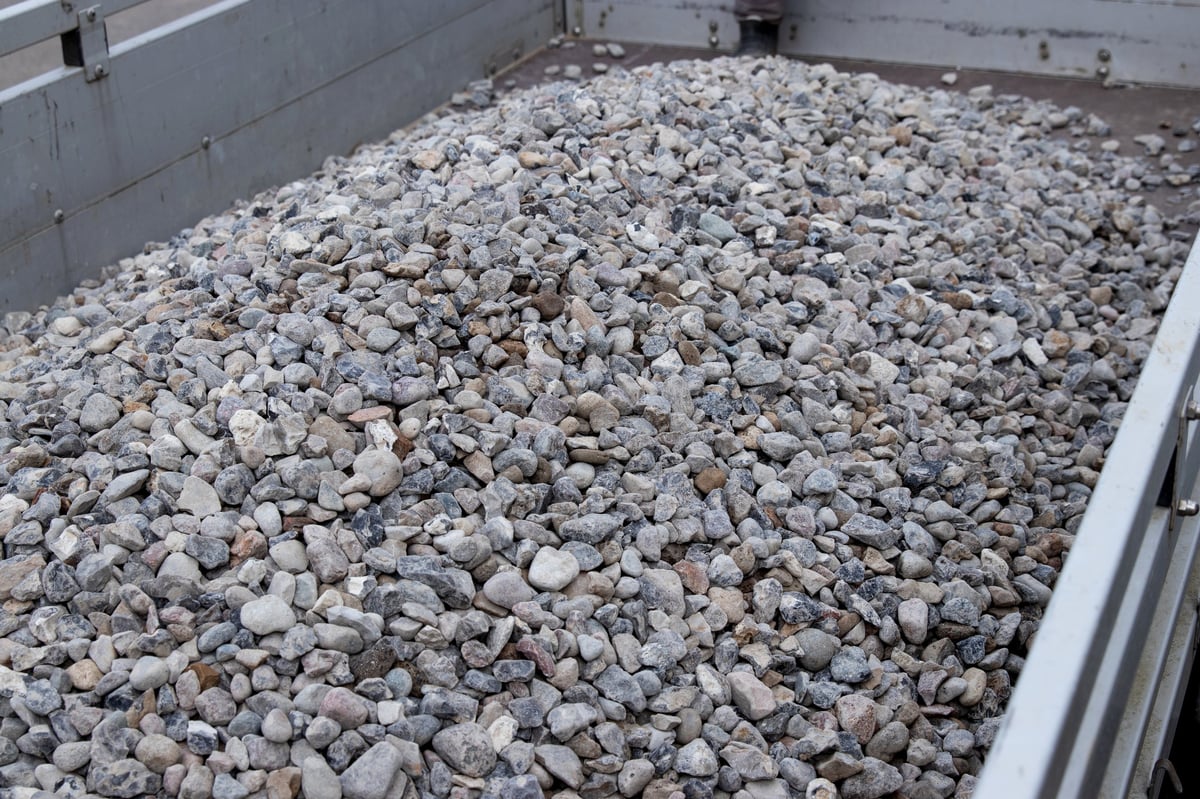 Small gray and white gravel stones fill the back of a truck, displaying a mix of sizes and shapes suitable for construction and landscaping projects